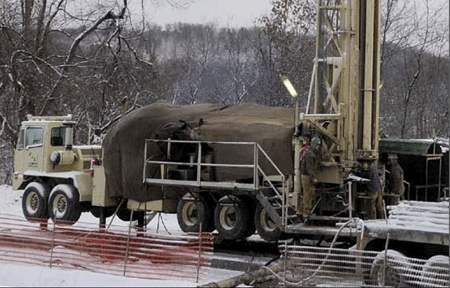 BLX crew tarps engine area of RD20 drill rig.Photo courtesy of BLX Inc.