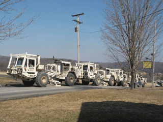 A convoy of vibroseis trucks cruisesdown a country road near Springville, PACourtesy of Peter Comly, - Clodhopper Farm